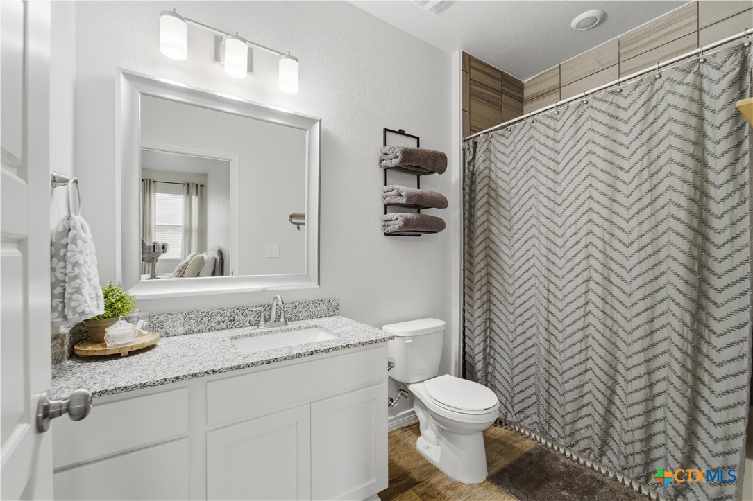 6003 Tivoli Road Temple, TX 76502 - Photo 20 of 30 a bathroom with a granite countertop sink mirror vanity and toilet