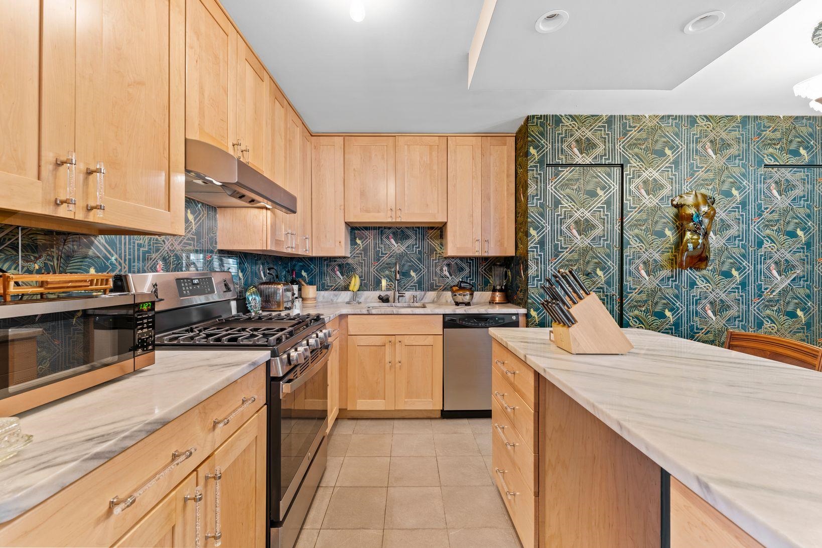 6040 Boulevard East, Unit MA West New York, NJ 07093 - Photo 15 of 35 a kitchen with stainless steel appliances kitchen island granite countertop a sink and cabinets