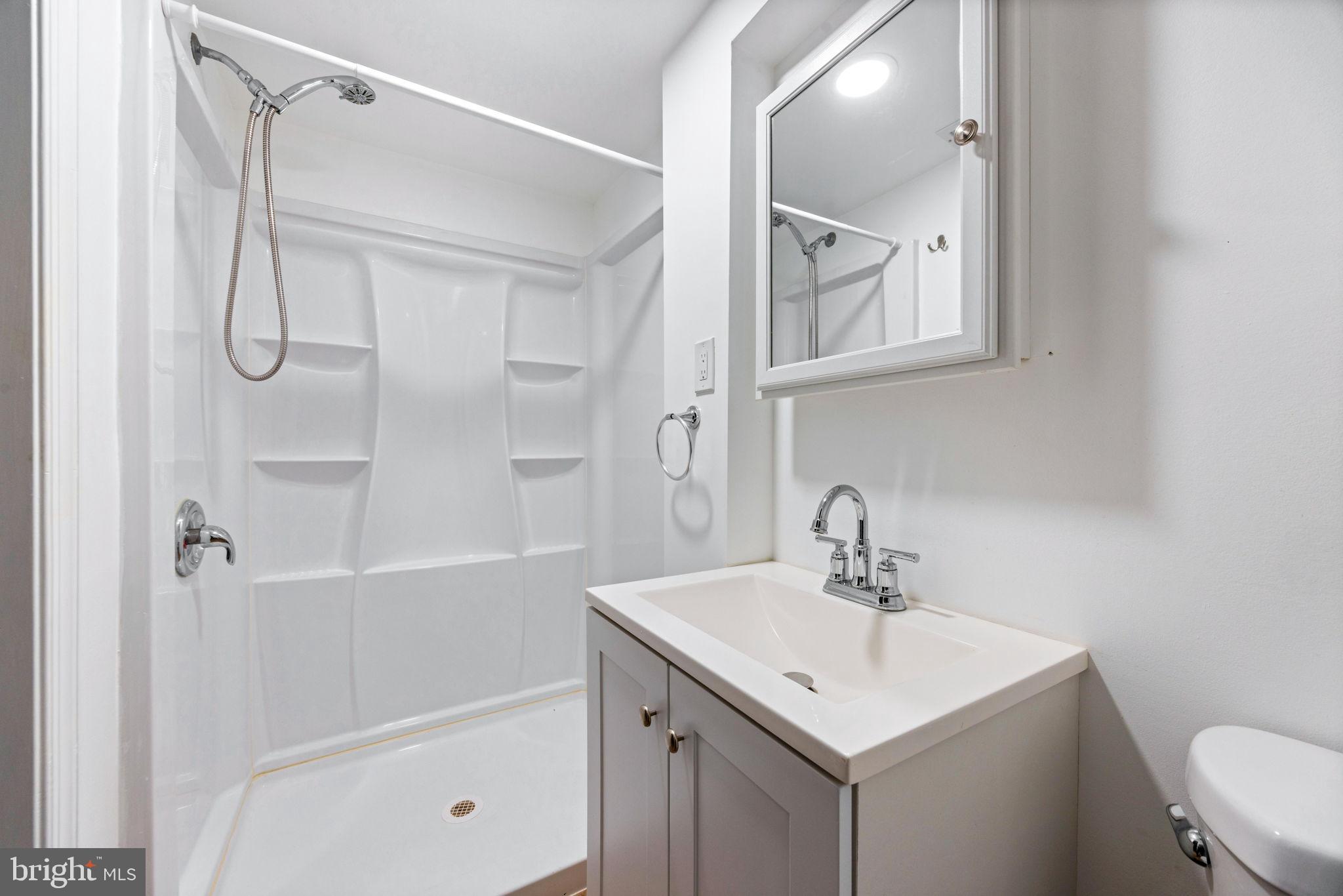 3807 Kimble Road Baltimore, MD 21218 - Photo 28 of 39 a bathroom with a sink a mirror a shower and a toilet