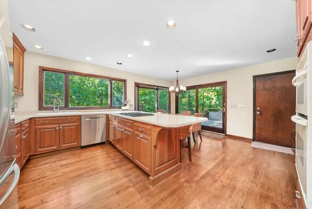 a large kitchen with stainless steel appliances granite countertop a large window and a sink