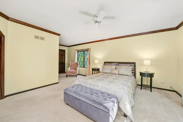 a spacious bedroom with a bed and a chandelier