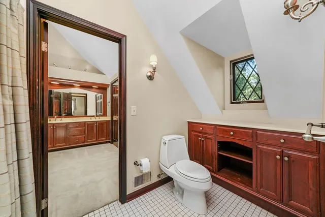 a bathroom with a toilet a sink and mirror