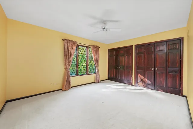 a view of an empty room with a window and bathroom