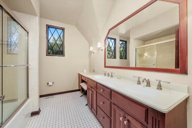 a bathroom with a sink a two mirror and a toilet