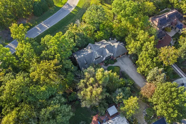 a sign of golf club on a wall under a tree