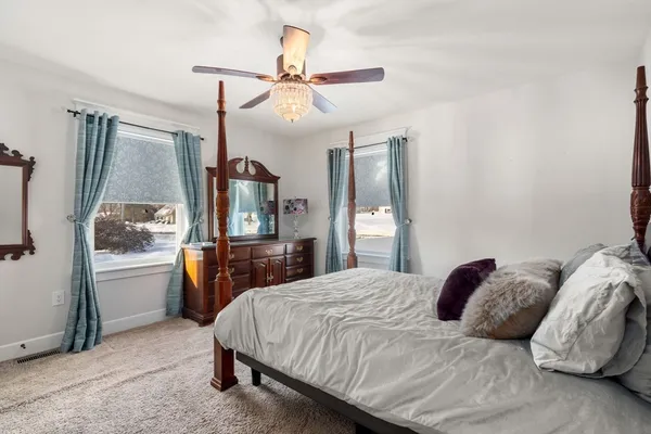 a bedroom with a large bed and a chandelier
