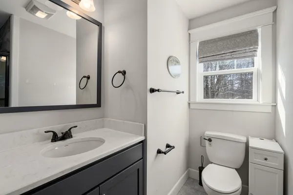 a bathroom with a toilet sink and mirror
