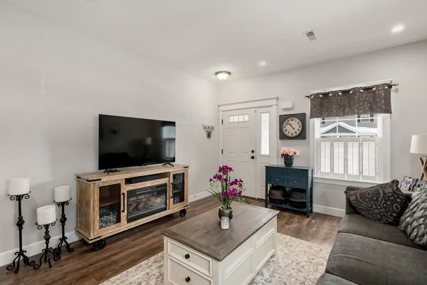 a living room with furniture a flat screen tv and a window