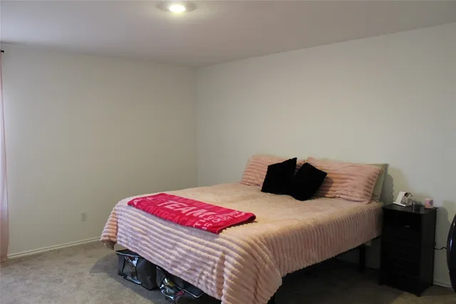 a bedroom with a bed and a lamp