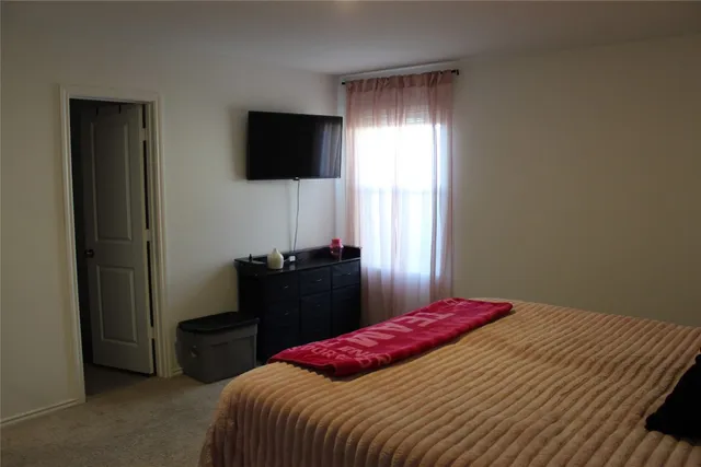 a bedroom with a bed and a flat screen tv