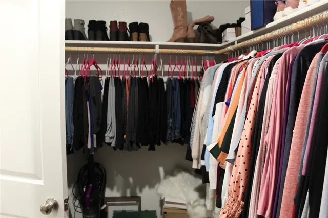 a view of walk in closet with clothes and shoes