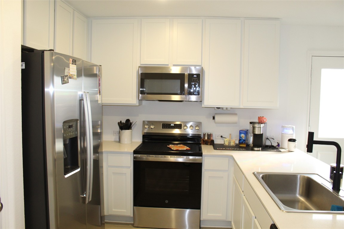 205 Marty Allen Loop Jarrell, TX 76537 - Photo 5 of 22 a kitchen with a sink and a refrigerator