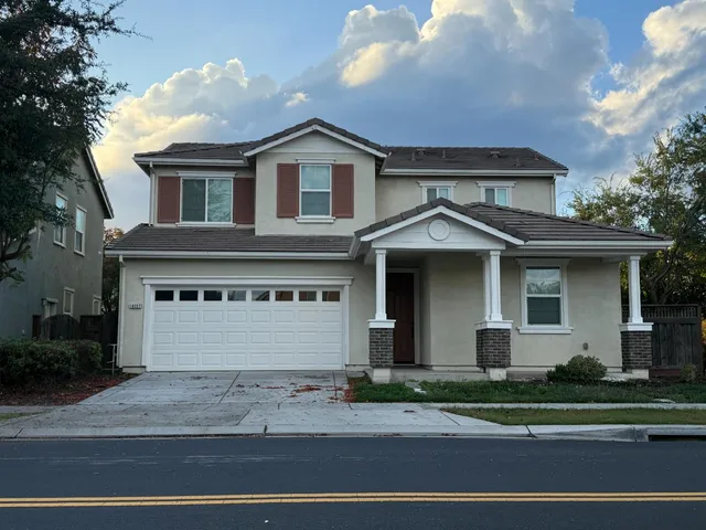 a front view of a house with a yard and garage