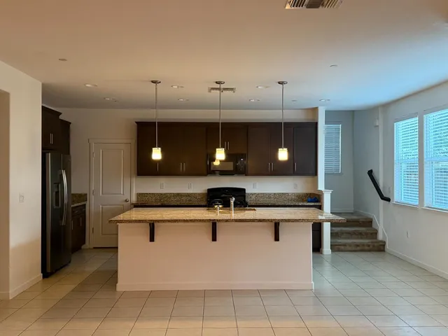 a kitchen with kitchen island stainless steel appliances a sink and a refrigerator