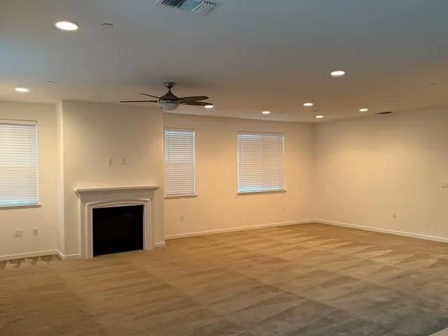 an empty room with windows and fireplace