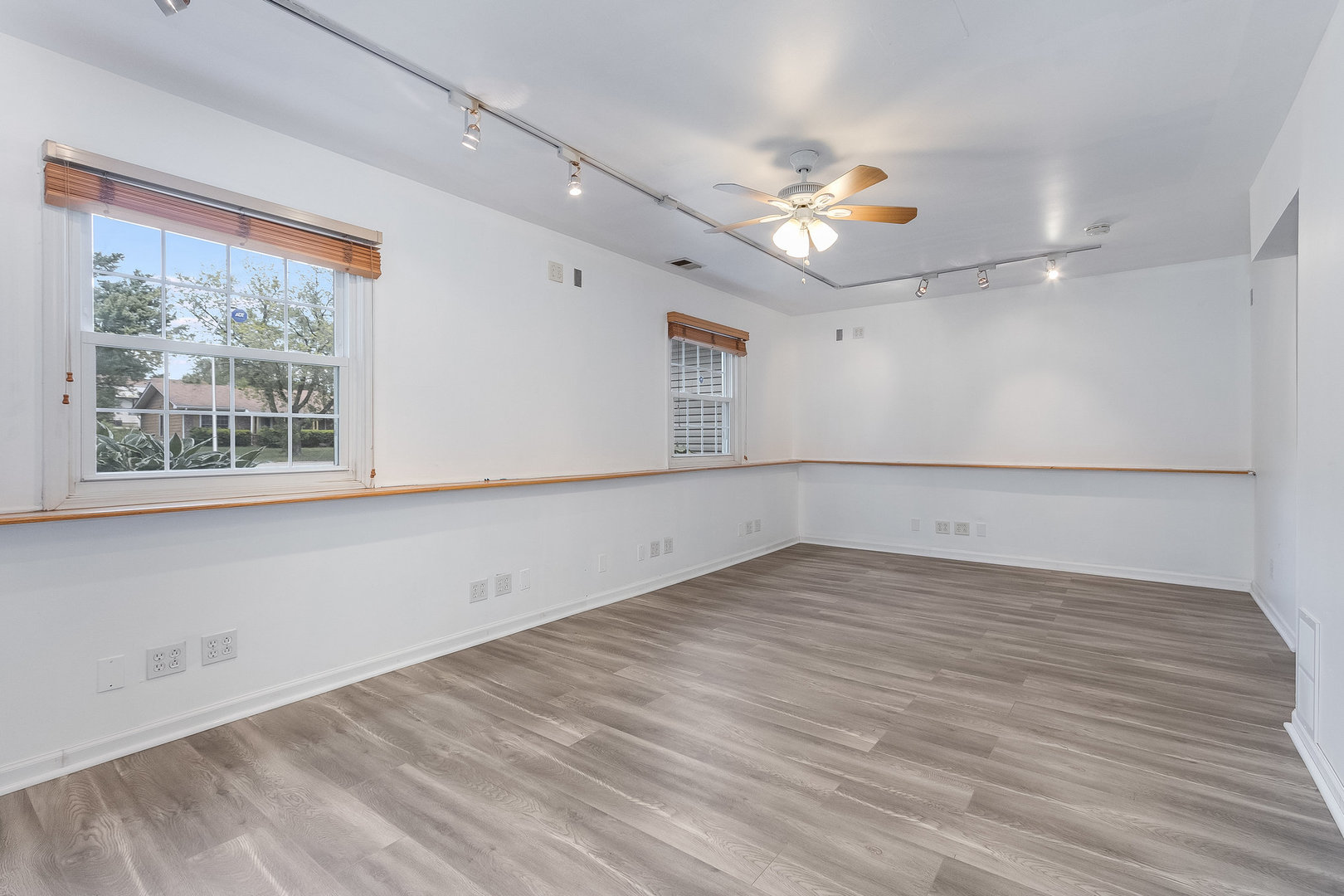 429 West Briarcliff Road Bolingbrook, IL 60440 - Photo 13 of 25 an empty room with wooden floor chandelier fan and windows