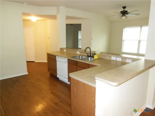 a kitchen with sink cabinets and a wooden floor