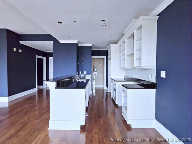 a living room with stainless steel appliances kitchen island hardwood floor and a view of living room