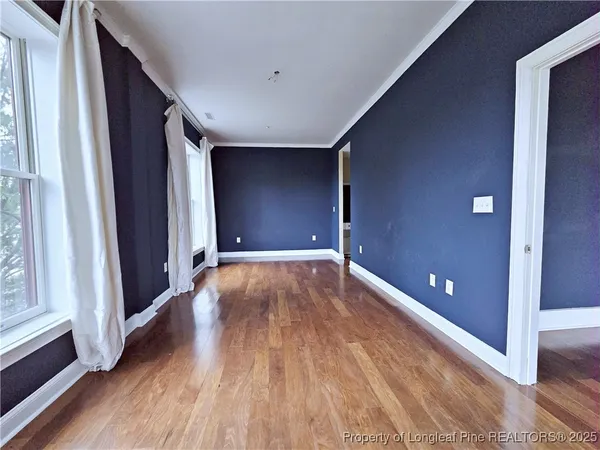 a view of empty room with wooden floor
