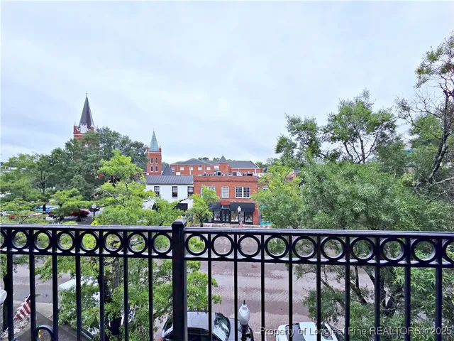 a view of a room with large windows and plants