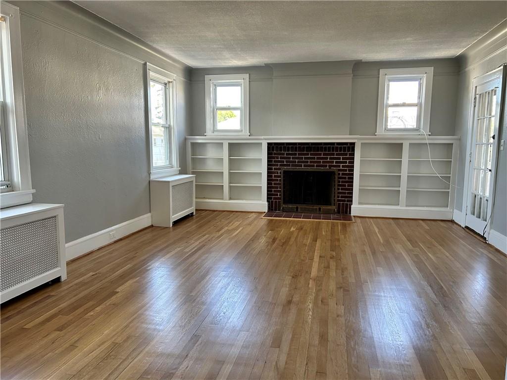 111 Prospect Street, Unit 2 Port Chester, NY 10573 - Photo 1 of 1 an empty room with wooden floor fireplace and windows