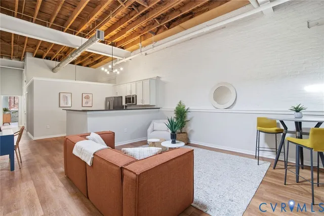 a living room with stainless steel appliances kitchen island granite countertop furniture and a rug