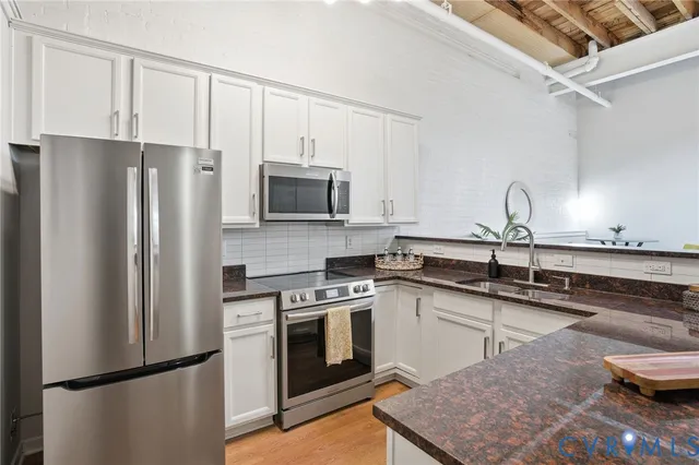 a kitchen with stainless steel appliances granite countertop a refrigerator sink and stove