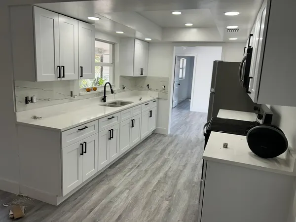 a large white kitchen with a large window