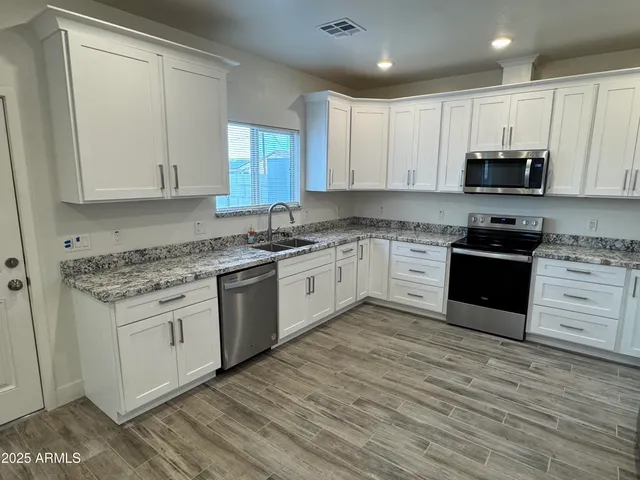 a kitchen with granite countertop white cabinets and white appliances