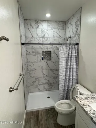 a bathroom with a granite countertop sink toilet and shower
