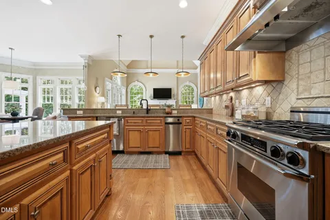 a kitchen with granite countertop a sink cabinets and stainless steel appliances