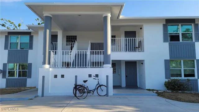 a front view of a house with lots of windows and plants