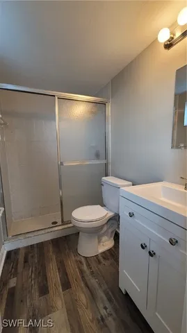 a view of a room with wooden floor and a ceiling fan