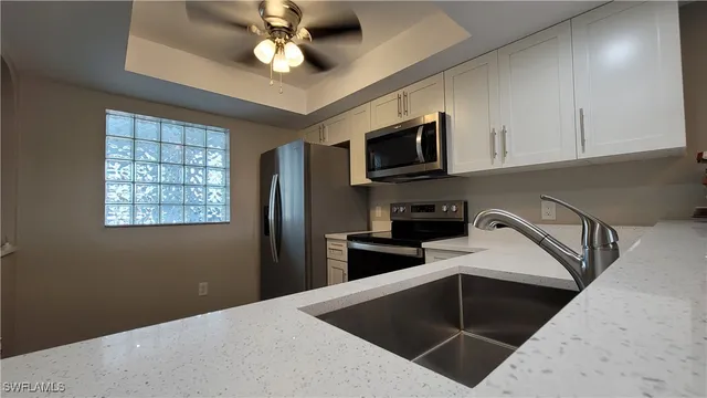 a view of a room with a ceiling fan and wooden floor