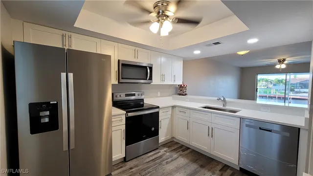 a kitchen with a sink stainless steel appliances and counter space