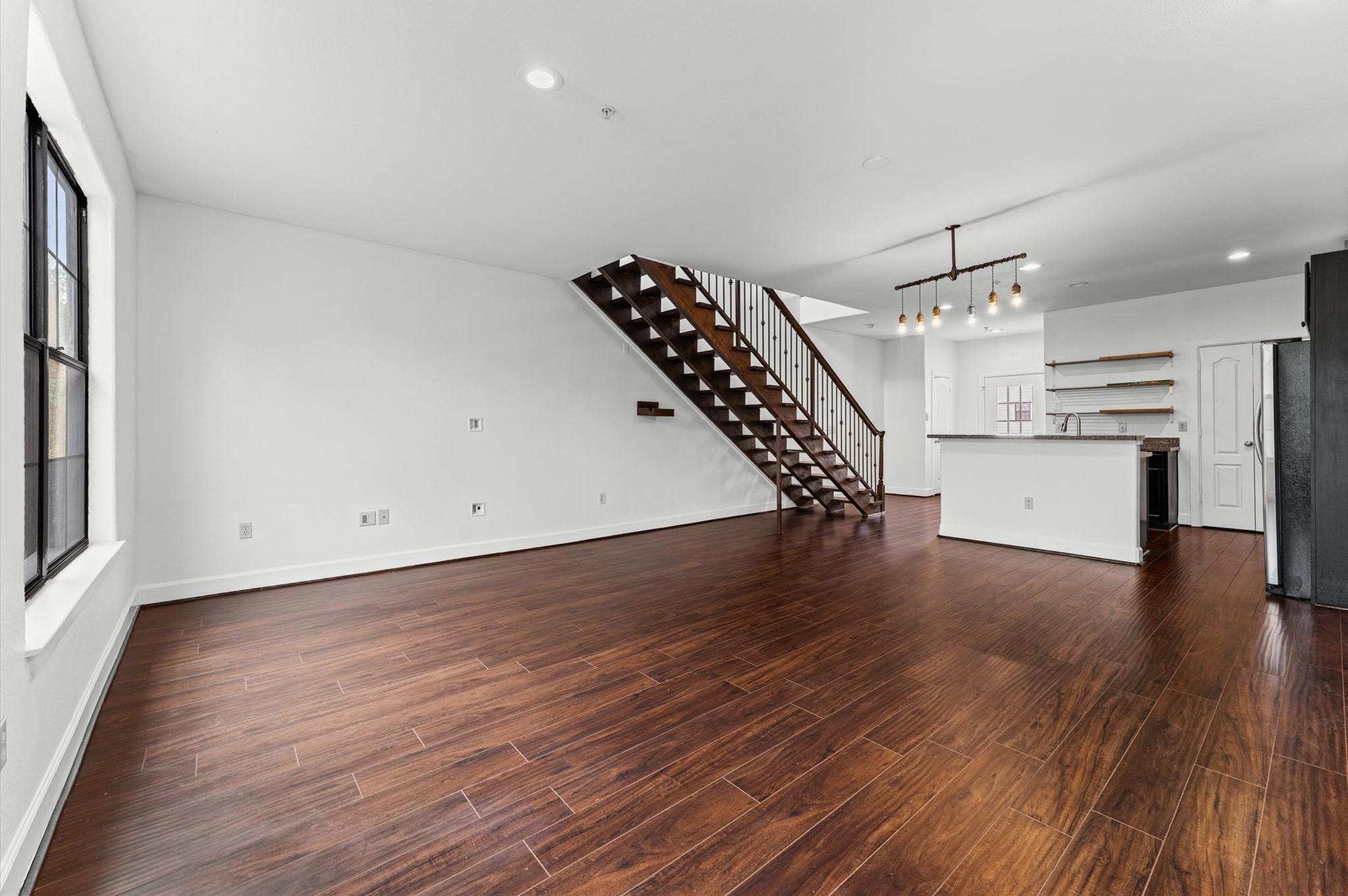 1602 Elgin Street, Unit 10 Houston, TX 77004 - Photo 2 of 21 The freshly painted interior features LVP floors, black-framed steel windows, and an open staircase that give the space a clean, modern character.