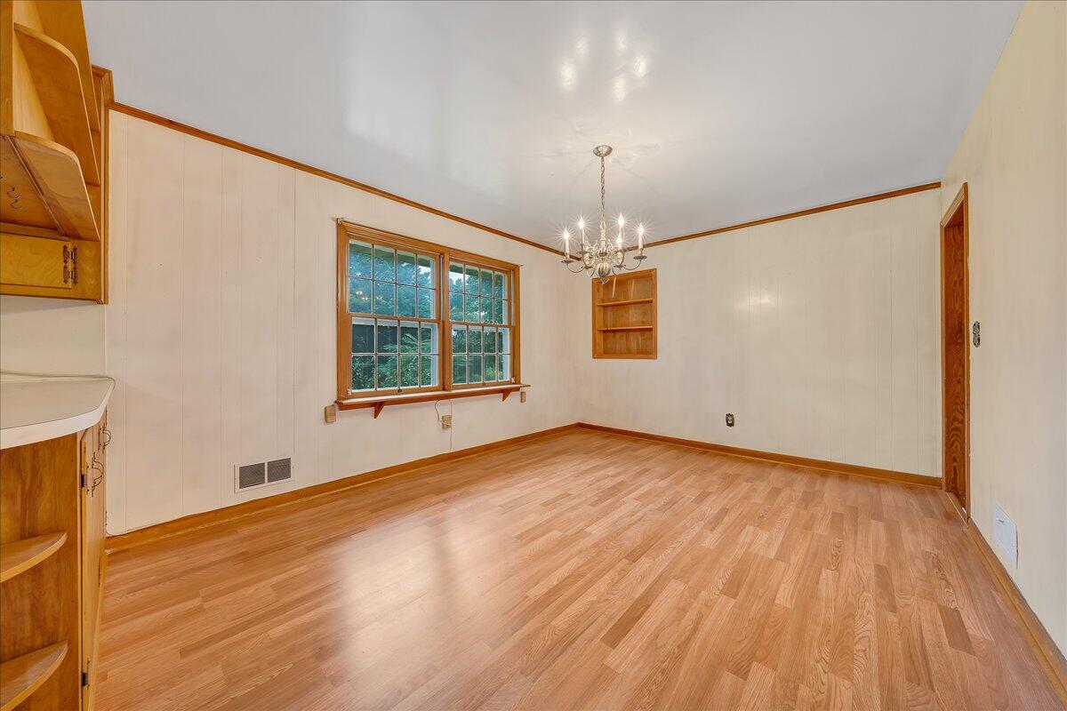 8450 Forest Road Goode, VA 24556 - Photo 24 of 49 an empty room with wooden floor chandelier and windows