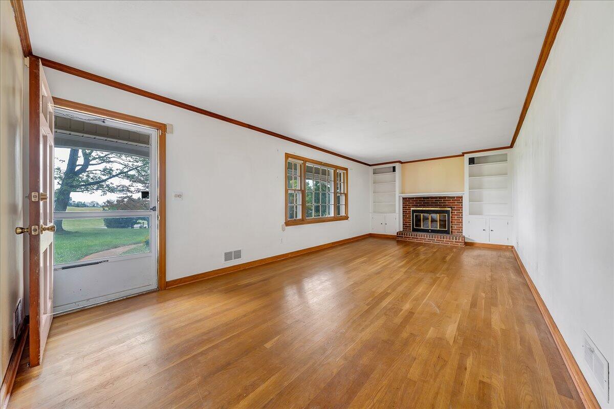8450 Forest Road Goode, VA 24556 - Photo 30 of 49 a view of empty room with wooden floor and fireplace