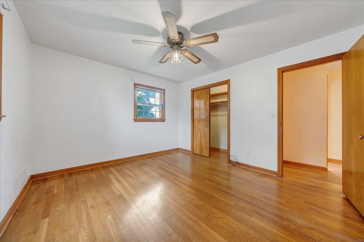 8450 Forest Road Goode, VA 24556 - Photo 39 of 49 an empty room with wooden floor chandelier fan and windows
