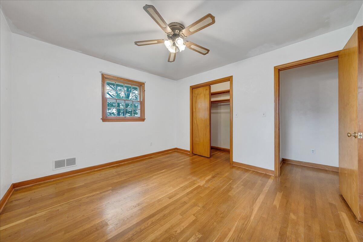 8450 Forest Road Goode, VA 24556 - Photo 40 of 49 a view of an empty room with wooden floor and a ceiling fan