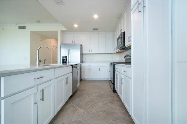 a kitchen with white cabinets and sink