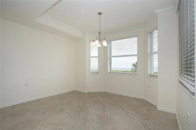 a view of a room with windows and chandelier fan