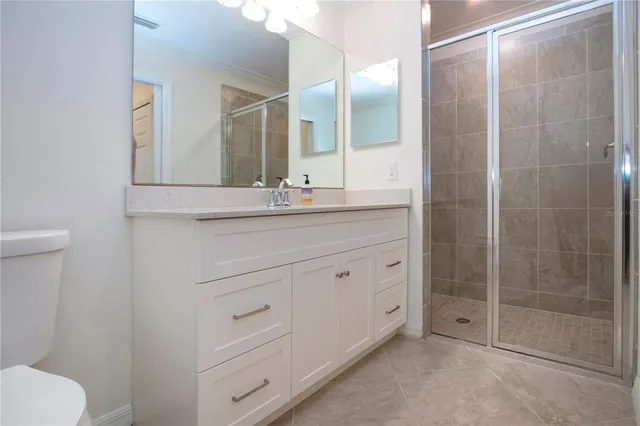 a bathroom with a shower sink and mirror