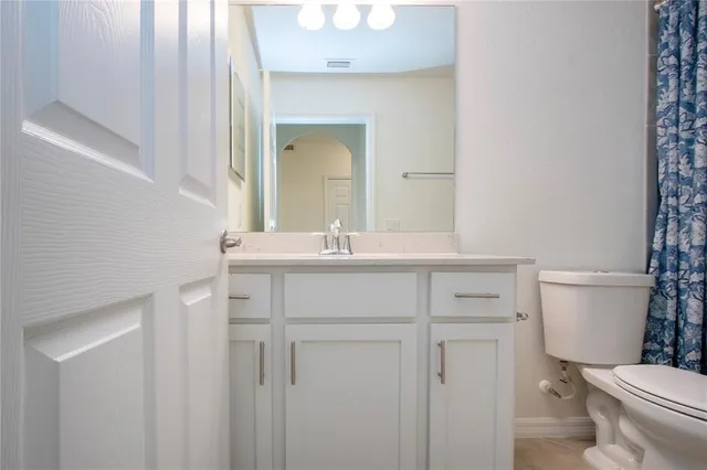 a bathroom with a sink vanity mirror and toilet
