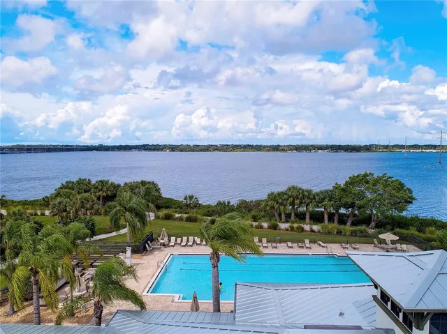 a view of a patio with table and chairs under an umbrella with a fireplace