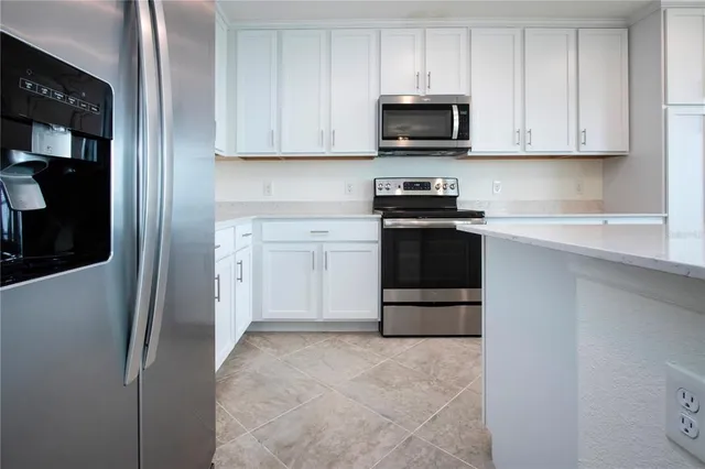 a kitchen with stainless steel appliances granite countertop a refrigerator and a stove top oven