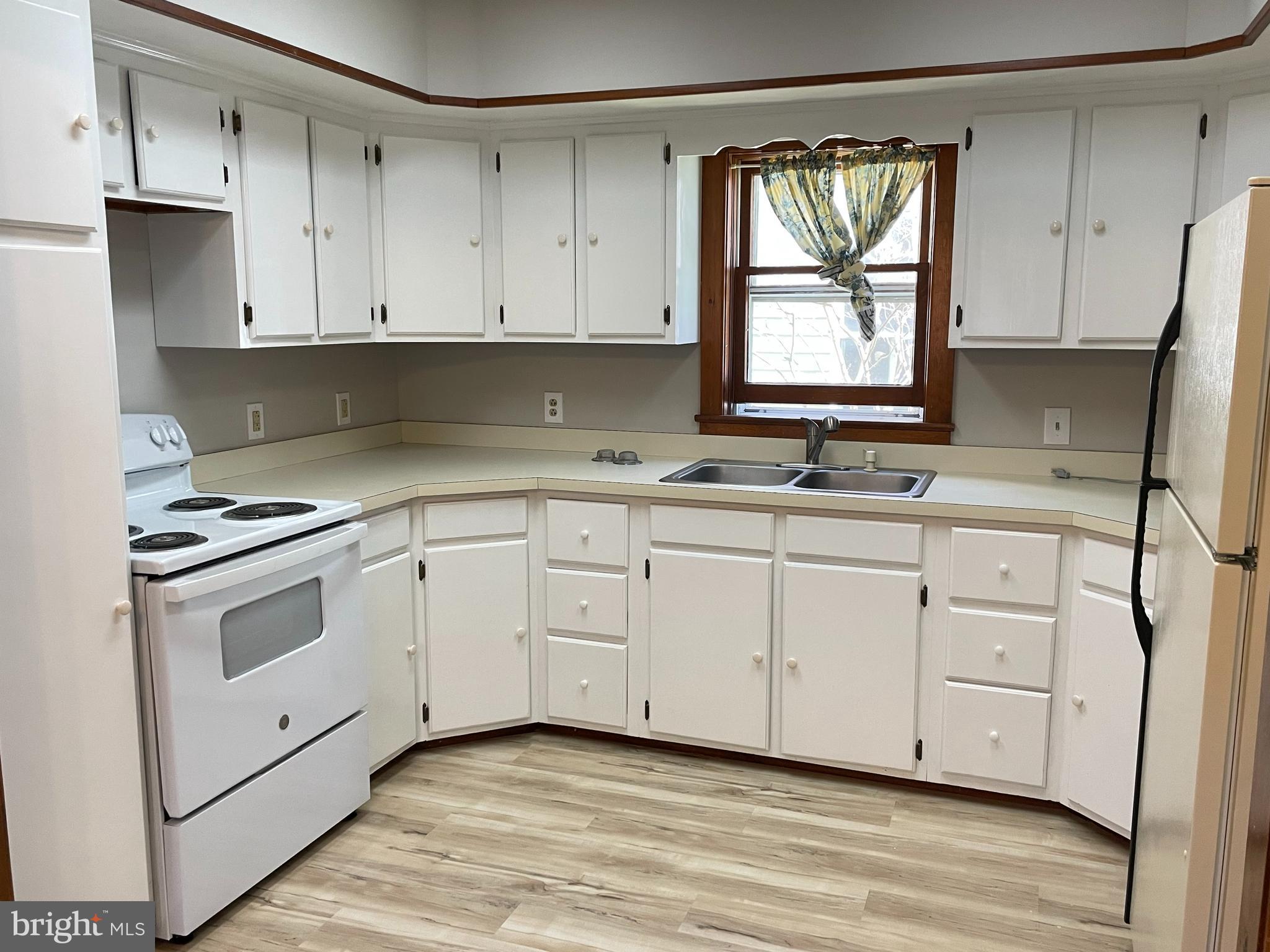 307 Willis Street Cambridge, MD 21613 - Photo 2 of 9 a kitchen with white cabinets white stainless steel appliances and sink
