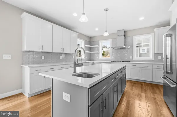 a kitchen that has a lot of cabinets in it and wooden floors
