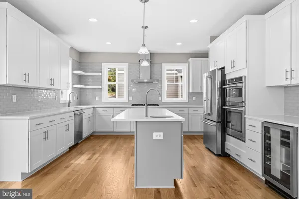 a kitchen with stainless steel appliances granite countertop a sink cabinets and wooden floor