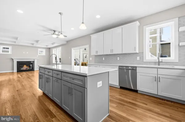 a kitchen with kitchen island granite countertop a sink cabinets and wooden floor